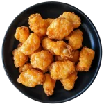 Close-up image of a crispy chicken wing drizzled with sauce, highlighting Wings Avenue’s flavor.